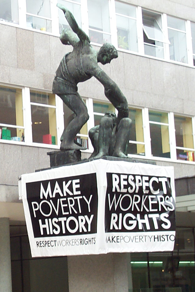 Eine Skulptur mit einem Plakat vor einem Gebäude