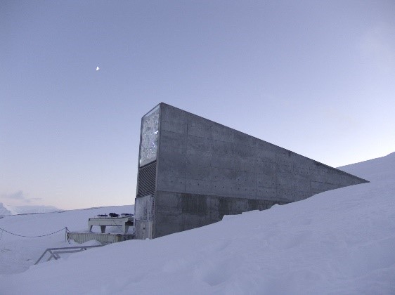 A gray building rising from a snow-covered landscape.