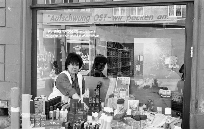 Naumburg (Sachsen-Anhalt), August 1991, Straßenverkauf einer Drogerie: „Aufschwung Ost“. Fotograf: Joachim F. Thurn. Quelle: Presse- und Informationsamt der Bundesregierung - Bildbestand (B 145 Bild) / Bundesarchiv B 145 Bild-F089039-0035 / Wikimedia Commons (CC-BY-SA 3.0)