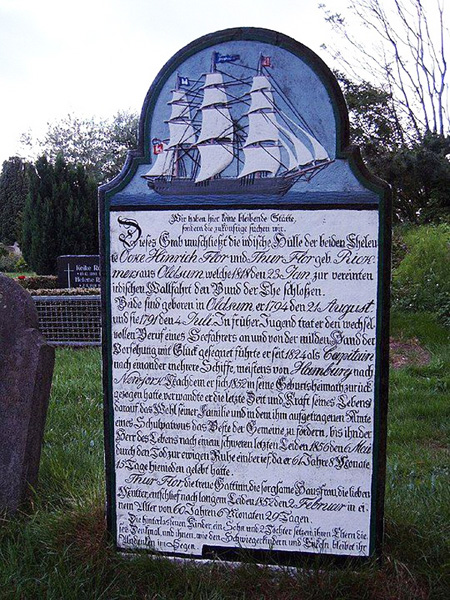 Blau-weißer Grabstein mit Segelschiff und darunter Text