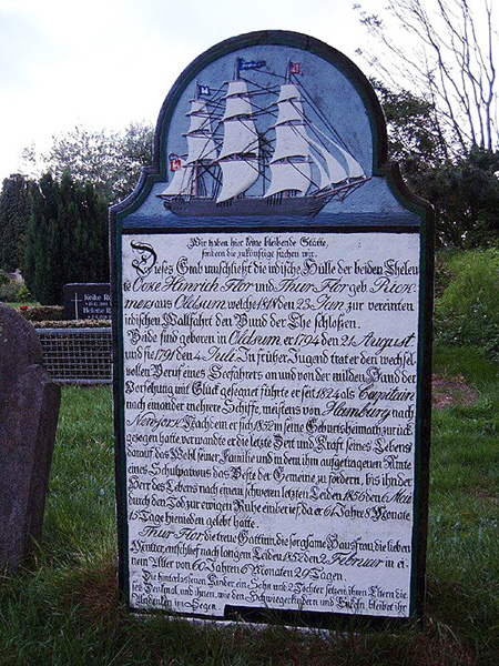 Blau-weißer Grabstein mit Segelschiff und darunter Text