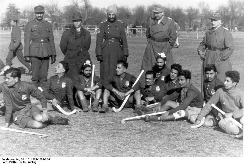 Hockeyspiel einer indischen gegen eine deutsche Wehrmachtsmannschaft, Frankreich, Atlantikwall, Stadion Bordeaux, 21. März 1944. Foto: Wette. Quelle: [https://commons.wikimedia.org/wiki/File:Bundesarchiv_Bild_101I-264-1604-05A,_Bordeaux,_Hockeyspiel_Wehrmachtsangeh%C3%B6riger.jpg?uselang=de Wikipedia / Bundesarchiv Bild 101l-264-1604-05A] ([https://creativecommons.org/licenses/by-sa/3.0/de/deed.de CC BY-SA 3.0 DE])