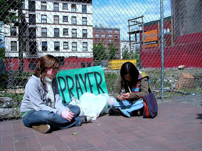 Betende junge Mädchen in Vancouver, 2008. Foto: unbekannt. Quelle: [http://commons.wikimedia.org/wiki/File:Rose_and_Tina_Pray_for_the_Downtown_Eastside.jpg?uselang=de Wikimedia Commons] ([https://de.wikipedia.org/wiki/Gemeinfreiheit gemeinfrei])