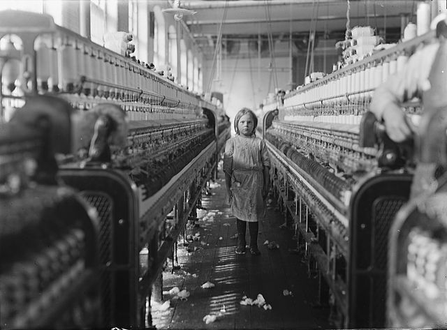 Lewis W. Hine: Child Laborer, 3. Dezember 1908. Original-Bildunterschrift: „A little spinner in the Mollohan Mills, Newberry, S.C. She was tending her 'sides' like a veteran, but after I took the photo, the overseer came up and said in an apologetic tone that was pathetic, 'She just happened in.' Then a moment later he repeated the information. The mills appear to be full of youngsters that 'just happened in,' or 'are helping sister.' Dec. 3, 08. Witness Sara R. Hine. Location: Newberry, South Carolina.” Quelle: [https://commons.wikimedia.org/wiki/File:Child_laborer.jpg#/media/File:Child_laborer.jpg Wikimedia Commons] / [http://loc.gov/pictures/resource/nclc.01451/ United States Library of Congress's Prints and Photographs Division ID nclc.01451], gemeinfrei