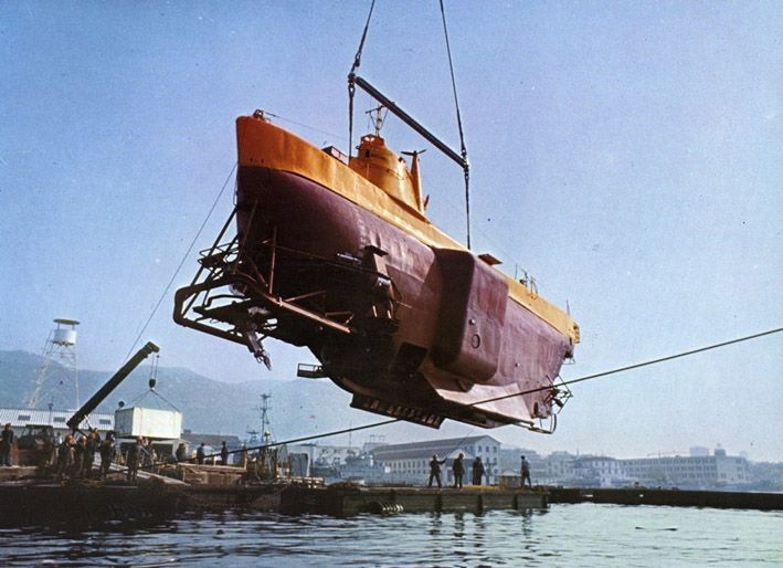 Im Kalten Krieg wurden extreme und lebensfeindliche Umwelten mit Hilfe von Technik erforscht und militärisch erschlossen. Auf der Fotografie wird das Bathyscaph „Archimède“, ein Tiefsee-U-Boot der französische Marine, zu Wasser gelassen (1961). Foto: Georges Houot, 28. Juli 1961. Quelle: [https://commons.wikimedia.org/wiki/File:Bathyscaphe_Archimede.jpg?uselang=fr Wikimedia Commons], Lizenz: public domain