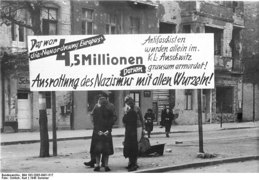 Transparent: „Das war die Neuordnung Europas. 4,5 Millionen Antifaschisten wurden allein im KL Auschwitz grausam ermordet! Darum Ausrottung des Nazismus mit allen Wurzeln“, Berlin-Neukölln, Hermannstraße, Ecke Warthestraße, 21. Juni 1945. Foto: Kurt Ochlich, Quelle: [https://commons.wikimedia.org/wiki/File:Bundesarchiv_Bild_183-2005-0901-517,_Berlin-Neuk%C3%B6lln,_Anti-NS-Transparent.jpg#/media/File:Bundesarchiv_Bild_183-2005-0901-517,_Berlin-Neuk%C3%B6lln,_Anti-NS-Transparent.jpg Bundesarchiv Bild 183-2005-0901-517 / Wikimedia-Commons], Lizenz: [https://creativecommons.org/licenses/by-sa/3.0/de/deed.en CC BY-SA 3.0]