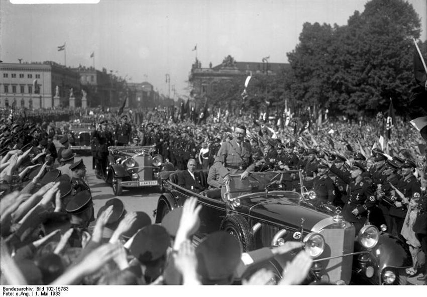 Wächst die Bewegung und gelangt der „Führer“ schließlich an die Macht, kommt zum inneren Kreis eine viel weiter ausgreifende „Gemeinde“ hinzu, die der „charismatischen Mission“ des „Führers“ erliegt und tendenziell die gesamte Gesellschaft oder doch mindestens große Teile derselben umfassen kann. <br />Adolf Hitler und Franz von Papen am 1. Mai 1933 im Lustgarten in Berlin. Fotograf: unbekannt, Quelle: [https://commons.wikimedia.org/wiki/File:Bundesarchiv_Bild_102-15783,_Berlin,_Lustgarten,_Maikundgebung.jpg Bundesarchiv, Bild 102-15783 / Wikimedia Commons], Lizenz: [https://creativecommons.org/licenses/by-sa/3.0/de/deed.en CC-BY-SA 3.0]